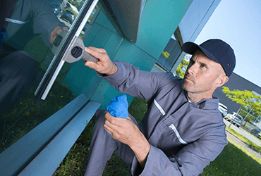 man washing windows of a business